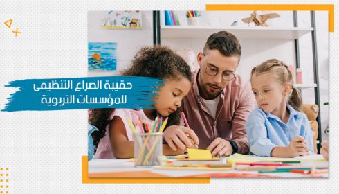 معلم يساعد طفلتين في الرسم، في بيئة تعليمية هادئة ومنظمة، مع نص جانبي يشير إلى "حقيبة الصراع التنظيمي في المؤسسات"، ليمثل أهمية إدارة الصراعات لتحقيق النجاح.